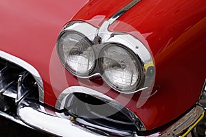 Classic American retro car bumper and headlight of red vintage car muscle