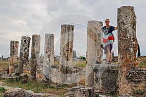 A classic antique Greek theater in Pamukkale, Denizli, Turkey and a white young woman in a hippie dress