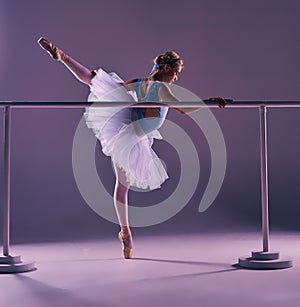 Classic ballerina posing at ballet barre