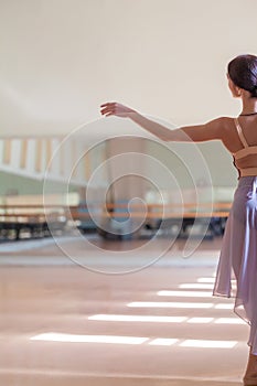 Classic ballet dancer posing at barre on rehearsal