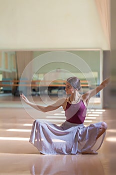 Classic ballet dancer posing at barre on rehearsal
