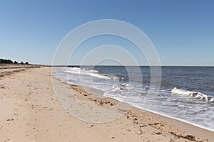 This is a classic beach shot taken at Cape May New Jersey. The pretty waves with the whitecaps. The sand riddles with pebbles.