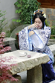 Classic beauty in China, woman in Hanfu dress, drinking tea