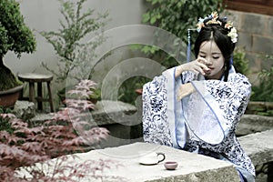 Classic beauty in China, woman in Hanfu dress, drinking tea