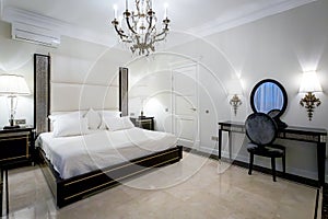 Classic bedroom interior with chandelier and floor lamps