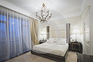 Classic bedroom interior with chandelier and floor lamps