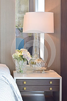 Classic bedroom interior with pillows and reading lamp on bedside table photo