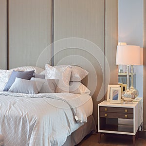 Classic bedroom interior with pillows and reading lamp on bedside table