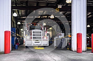 Classic big rig semi truck is being serviced in a specialized workshop equipped for semi truck repairs and maintenance