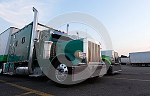 Classic big rig semi trucks in line on truck stop