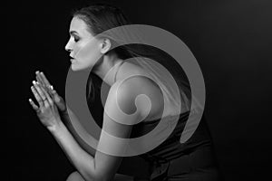 Classic black-and-white dramatic portrait of an adult blonde woman in Studio on black background