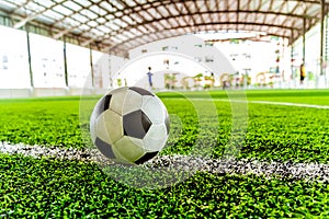 classic black and white football soccer ball on training pitch with blur background