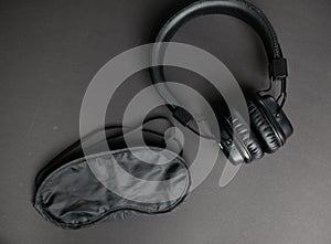 Classic black wired headphones on black paper background. Retro style. 80s. Pop culture.Minimal Music Concept