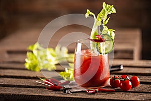 Classic bloody mary or virgin mary vodka cocktail in a cup with as a hangover drink in a rustic envrionment