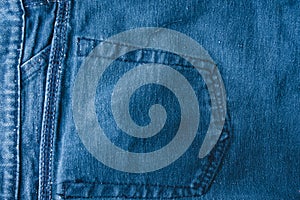 Classic blue jeans background. Denim texture fabric with a seam of fashionable design. Empty pattern copy space. Selective focus