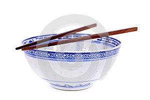 Classic blue pattern empty Chinese rice bowl with wooden chopsticks isolated on white background