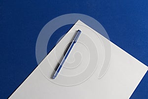 Classic blue table with blank sheet of paper and blue pen ready for 2020 goals photo