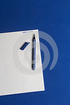 Classic blue table with pen and white sheet of paper ready for the goals of the year. On paper it says in Spanish January 2020