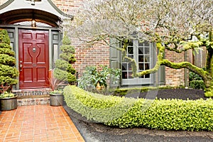 Classic brick house entrance with trim hedge