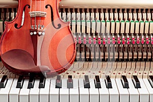 classic brown violin on the close up image of grand piano keys and interior background