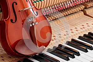 classic brown violin on the close up image of grand piano keys and interior background