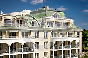 Classic building with arcs om balconies and green metal roof