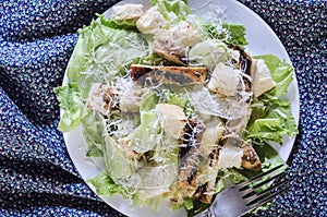 Classic caesar chicken salad on wooden table above view