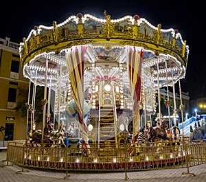 Classic carousel illuminated at night at the fair