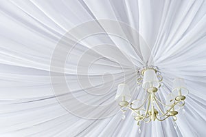 Classic chandelier hanging on ceiling made of white cloth