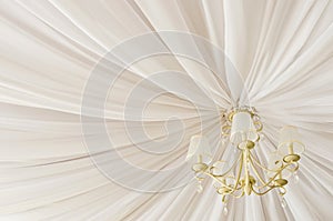 Classic chandelier hanging on ceiling made of white cloth