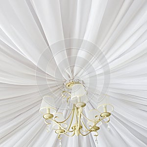 Classic chandelier hanging on ceiling made of white cloth