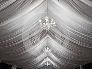 Classic chandeliers on party tent photo