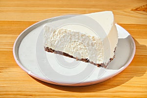 Classic cheesecake on white plate on  wooden table