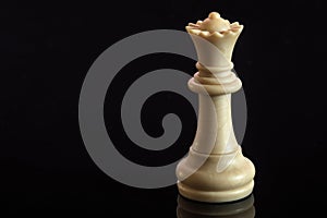 Classic Chess White Queen on black surface, isolated