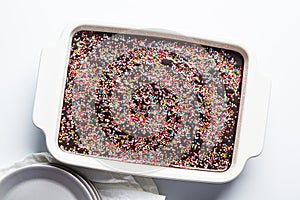 Classic chocolate cake with colored sprinkles in baking dish