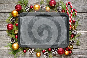 Classic christmas and new year composition chalk board, balls, toys, candy, fir branches on vintage wooden background