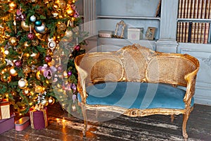 Classic Christmas New Year decorated interior room home library with fireplace. Christmas tree with gold ornament decorations.