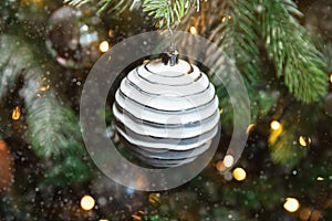 Classic Christmas New Year decorated New year tree with white ornament decorations toy and ball, snow and defocused