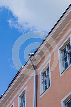 Classic city house with downpipe under blue sky