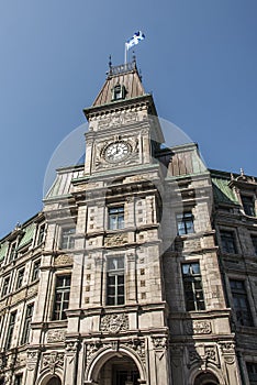 Classic clocktower building Quebec City Canada with flag of quebec on a sunny day blue sky