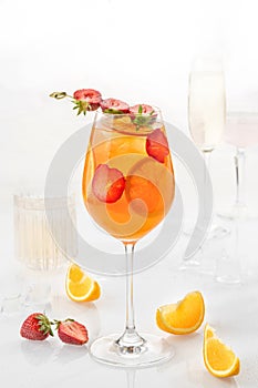 Classic cocktail in glass on white background with orange, alcohol, strawberry  soda and ice