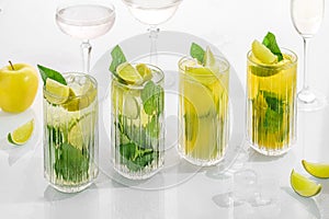 Classic cocktail mix of different lemonades , mohito in glass on white background with lime, lemon, mint, apple ,soda,  alcohol