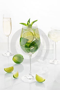 Classic cocktail mix mohito in glass on white background with lime, lemon, mint, soda,  alcohol