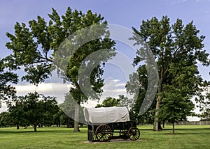 Classic covered wagon with trees in a park