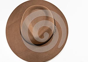 Classic cowboy brown felt hat with strap and copper closure on white background