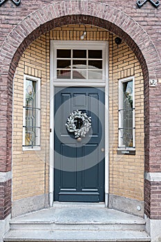 Classic Dark Door with Wreath on a Brick Building