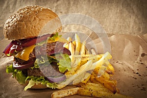 Classic deluxe cheeseburger with lettuce, onions, tomato and pickles on a sesame seed bun