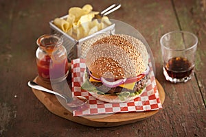 Classic deluxe cheeseburger with lettuce, onions, tomato and pickles on a sesame seed bun