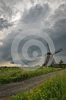 Classic dutch landscape with windmill and stormclouds