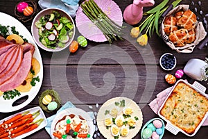 Classic Easter ham dinner. Overhead view frame on a dark wood background with copy space.